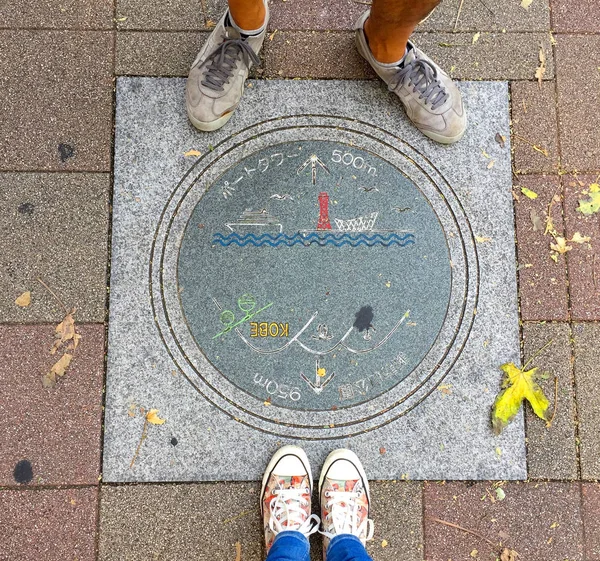 Vrouwelijke en mannen poten staan voor een prachtig versierd mangat van Kobe City, Japan — Stockfoto