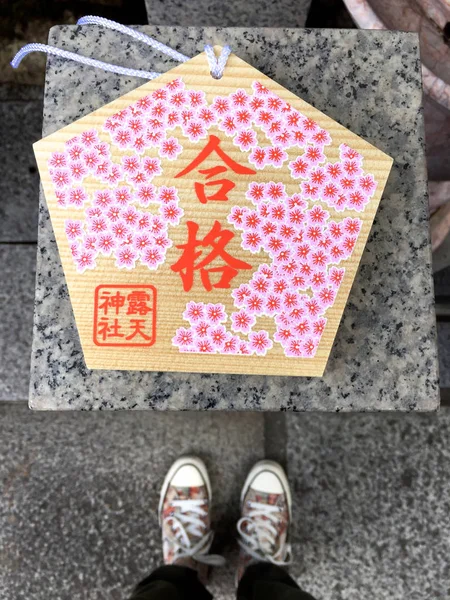 Pies femeninos de pie frente a una placa votiva (Ema) en Osaka —  Fotos de Stock