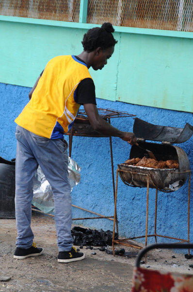 Jamaican man is cooking Jerk chicken