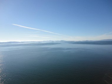 Kıyı boyunca iç görünümünü Alaska pasajda. Parlak mavi gökyüzü ve kapalı ufuk içine uzanan su. Huzur içinde sakin okyanus.