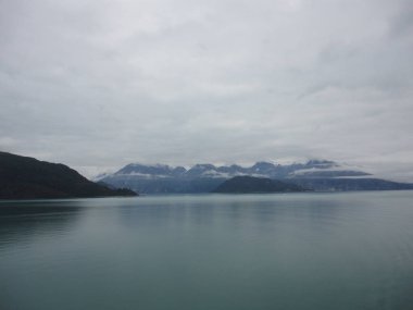 Pasifik Okyanusu iki dağ arasındaki geçiş. Yavaş yavaş akan bir bulutlu gökyüzü altında sakin huzurlu suları.