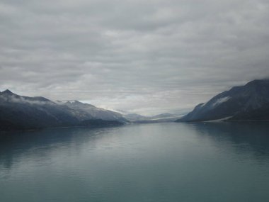 Pasifik Okyanusu iki dağ arasındaki geçiş. Yavaş yavaş akan bir bulutlu gökyüzü altında sakin huzurlu suları.