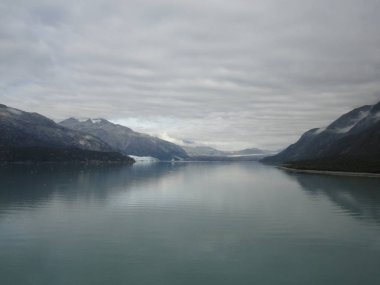 Pasifik Okyanusu iki dağ arasındaki geçiş. Yavaş yavaş akan bir bulutlu gökyüzü altında sakin huzurlu suları.