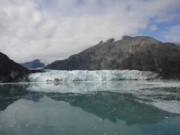 氷河はすぐ後ろに小さな山のピークと太平洋の海に滑ります スタークと荒涼とした風景 — ストック写真
