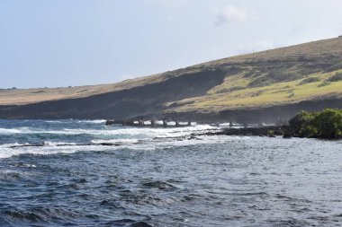 Dalgalar mavi bir gökyüzü altında kayalar üzerinde yıkamak gibi Hawaii beyaz köpük Rocky Shore üzerinde çökmesini dalgalar