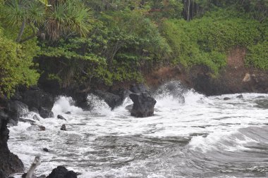 Dalgalar mavi bir gökyüzü altında kayalar üzerinde yıkamak gibi Hawaii beyaz köpük Rocky Shore üzerinde çökmesini dalgalar