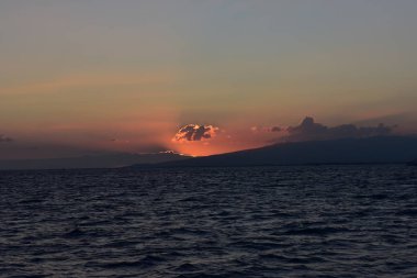 Hawaii 'de Pasifik Okyanusu üzerinde günbatımı parlak gökyüzü dağ ve gökyüzü renkleri her türlü atma bulutu arkasında daldırma