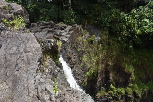 レインボーフォールズダウンタウンヒロハワイ滝ジャングルに囲まれたプールに岩だらけの床の間をカスケード — ストック写真