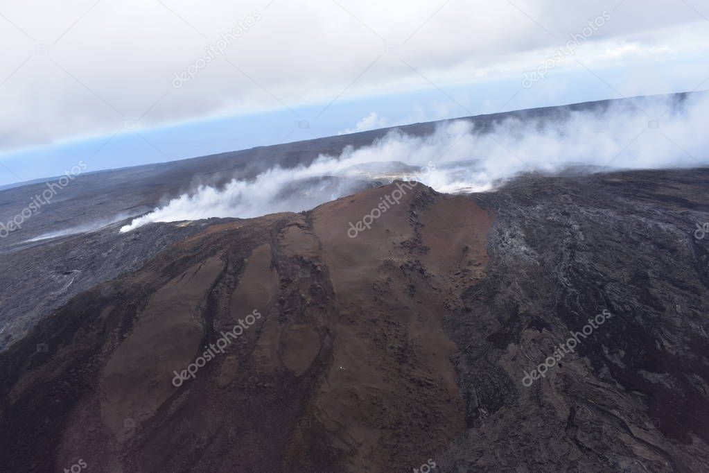 Arial View of Mauna Loa Volcano Crater Hawaii Smoke billowing from the crater and fissures as magma leaks to the surface