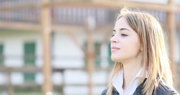 Sonriente mujer respirando, luego mirando a la cámara y lejos — Vídeos de Stock