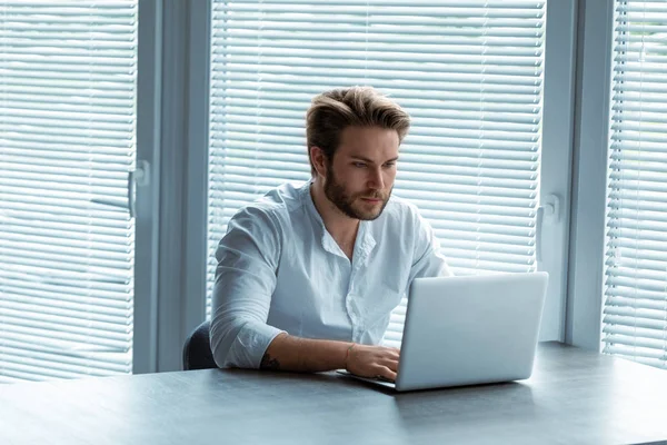 Ernstige Jonge Zakenman Die Werken Een Laptopcomputer Met Een Blik — Stockfoto