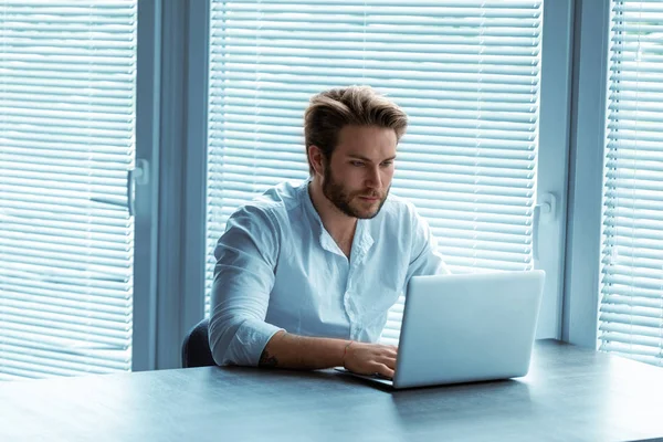 Uomo Attraente Seduto Lavorare Presso Computer Portatile Tavolo Ufficio Digitando — Foto Stock