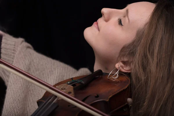 严肃和集中的小提琴运动员 一个妇女的画像在黑背景演奏弦 — 图库照片