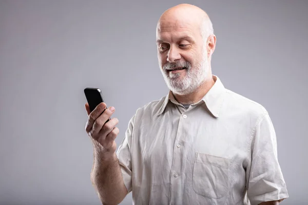 Reifer Mann Schaut Zufrieden Auf Sein Smartphone Und Das Internet — Stockfoto