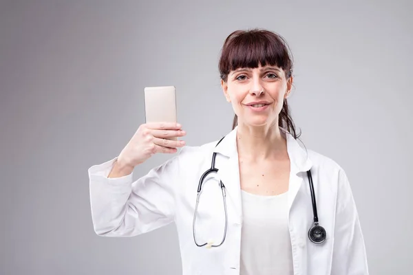 Usmívající Žena Lékař Zvedl Její Mobilní Telefon Jak Vypadá Kameru — Stock fotografie