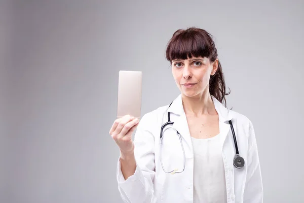 Médica Feminina Segurando Telefone Celular Levantado Mão Com Uma Expressão — Fotografia de Stock