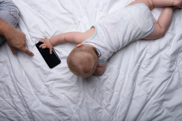 Kleine Pasgeboren Baby Bereiken Voor Een Mobiele Telefoon Aanraken Van — Stockfoto