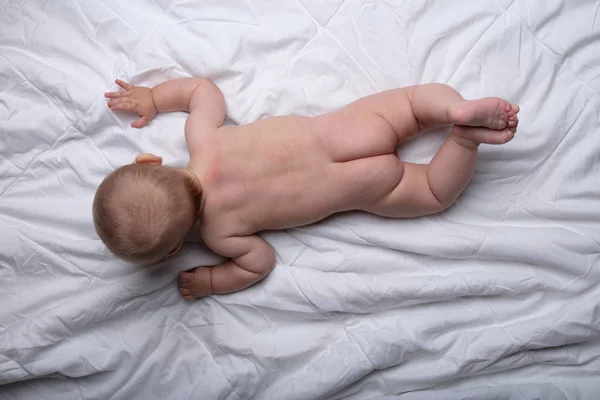 Lindo Bebé Desnudo Acostado Sobre Estómago Una Cama Blanca Vista —  Fotos de Stock