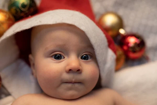 Bayi Kecil Topi Santa Mengenakan Topi Merah Tergeletak Sofa Dengan — Stok Foto