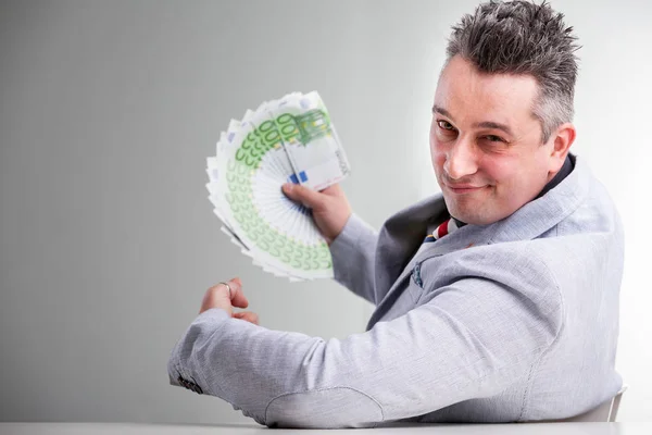 Pebisnis tersenyum memegang segenggam uang kertas — Stok Foto