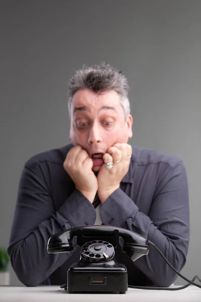 Anxious man looking at a phone in trepidation — Stock Photo, Image