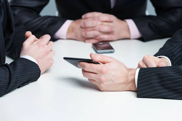 Handen van drie zakenlui in een vergadering — Stockfoto
