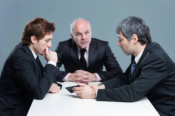 Drei Geschäftsleute im ernsthaften Gespräch — Stockfoto