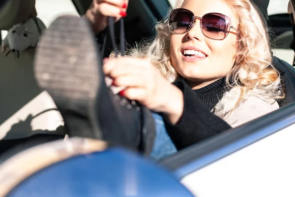 Jovem loira motorista feminino amarrando seus atacadores — Fotografia de Stock