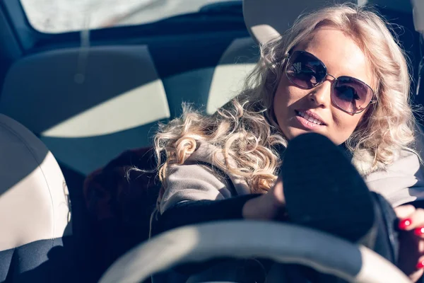 Jonge vrouw bestuurder worstelen om te zetten op schoenen — Stockfoto