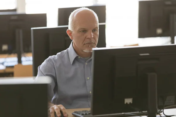 Engagierter Senior-Geschäftsmann arbeitet am Schreibtisch — Stockfoto