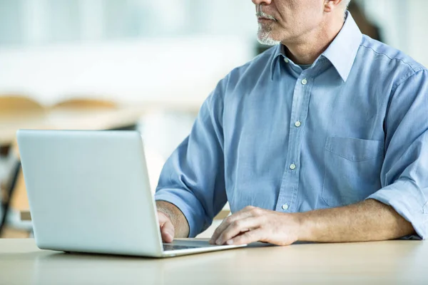 Empresário em mangas de camisa trabalhando em um laptop — Fotografia de Stock