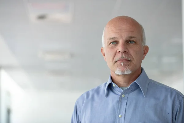 Serious senior man staring intently at the camera — Stock Photo, Image