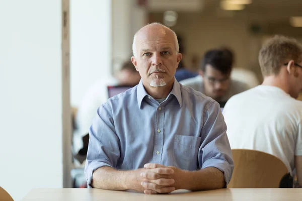 Kafeteryada tek başına oturan ciddi yaşlı adam — Stok fotoğraf