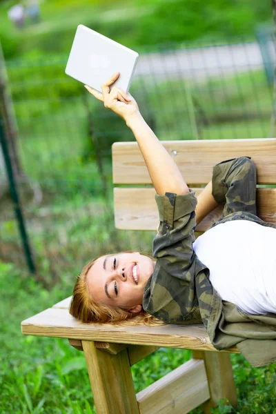 나무 벤치에서 휴식을 취하는 귀여운 젊은 여성 — 스톡 사진