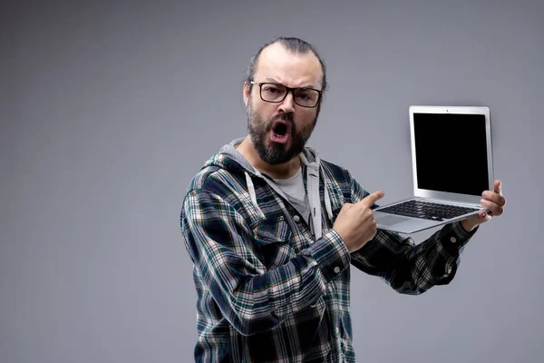 Аргументативний іронічний чоловік вказує на свій ноутбук — стокове фото