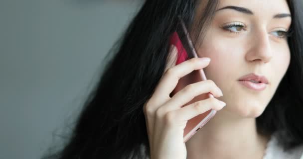 ピンクのスマートフォンで話すフリーランスの女性 — ストック動画
