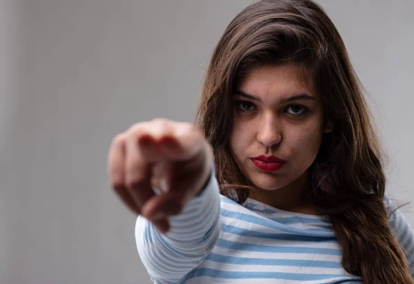 Mujer joven señalando un dedo acusatorio — Foto de Stock