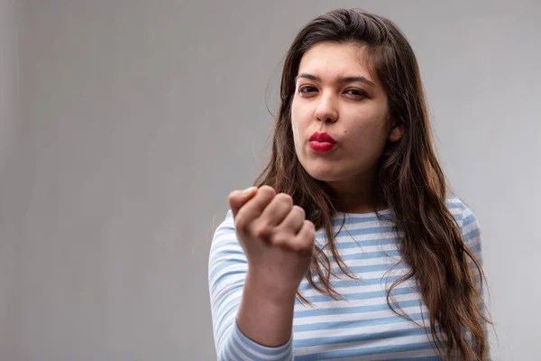 Mujer joven amenazante blandiendo su puño — Foto de Stock