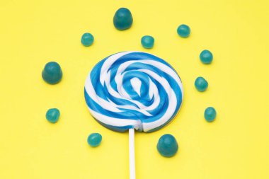 renkli yuvarlak lolipop ve Sarı zemin üzerine şeker çeşitleri