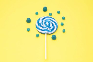 renkli yuvarlak lolipop ve Sarı zemin üzerine şeker çeşitleri