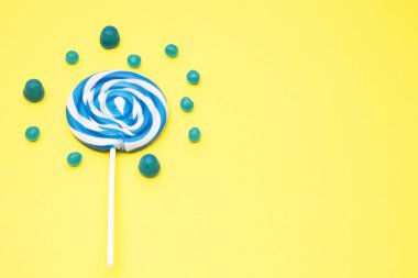 renkli yuvarlak lolipop ve Sarı zemin üzerine şeker çeşitleri