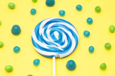 renkli yuvarlak lolipop ve Sarı zemin üzerine şeker çeşitleri