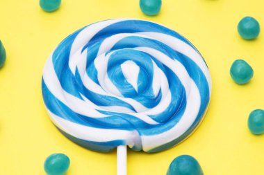 renkli yuvarlak lolipop ve Sarı zemin üzerine şeker çeşitleri