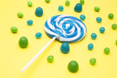 renkli yuvarlak lolipop ve Sarı zemin üzerine şeker çeşitleri
