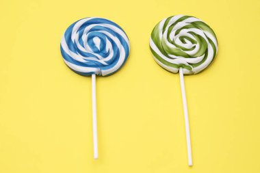Sarı arka plan üzerinde renkli sarmal lolipop