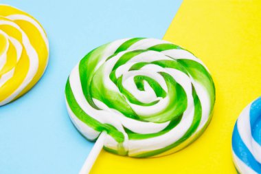 sarı ve mavi arka plan üzerinde renkli lolipop