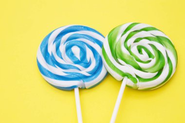 sarı arka plan üzerinde renkli lolipop