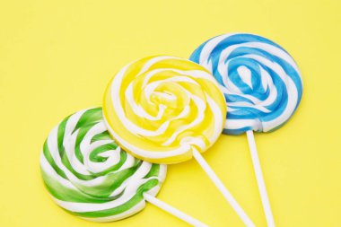 sarı arka plan üzerinde renkli lolipop