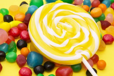 renkli lolipop ve sarı zemin üzerine şeker çeşitleri