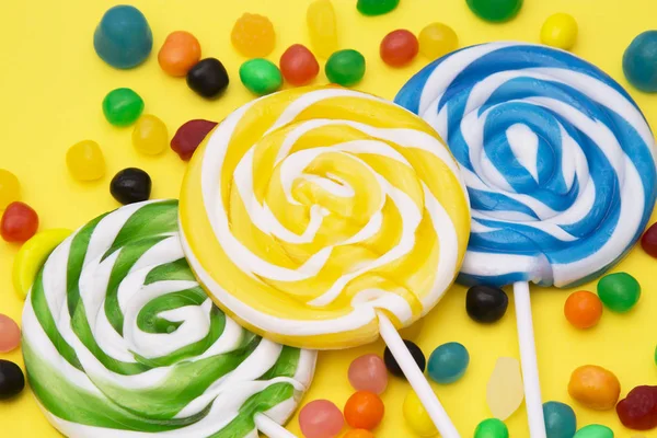 renkli lolipop ve sarı zemin üzerine şeker çeşitleri